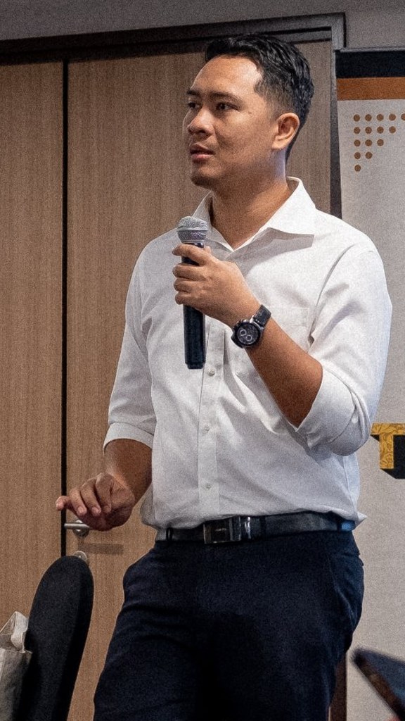 Luqman Long speaking with a microphone at a KL Debate session